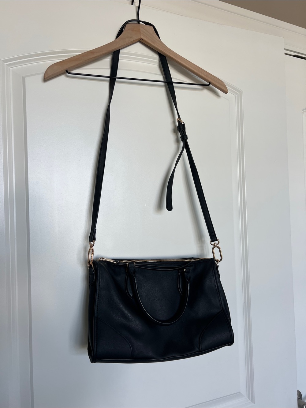 Black purse with adjustable straps and handles